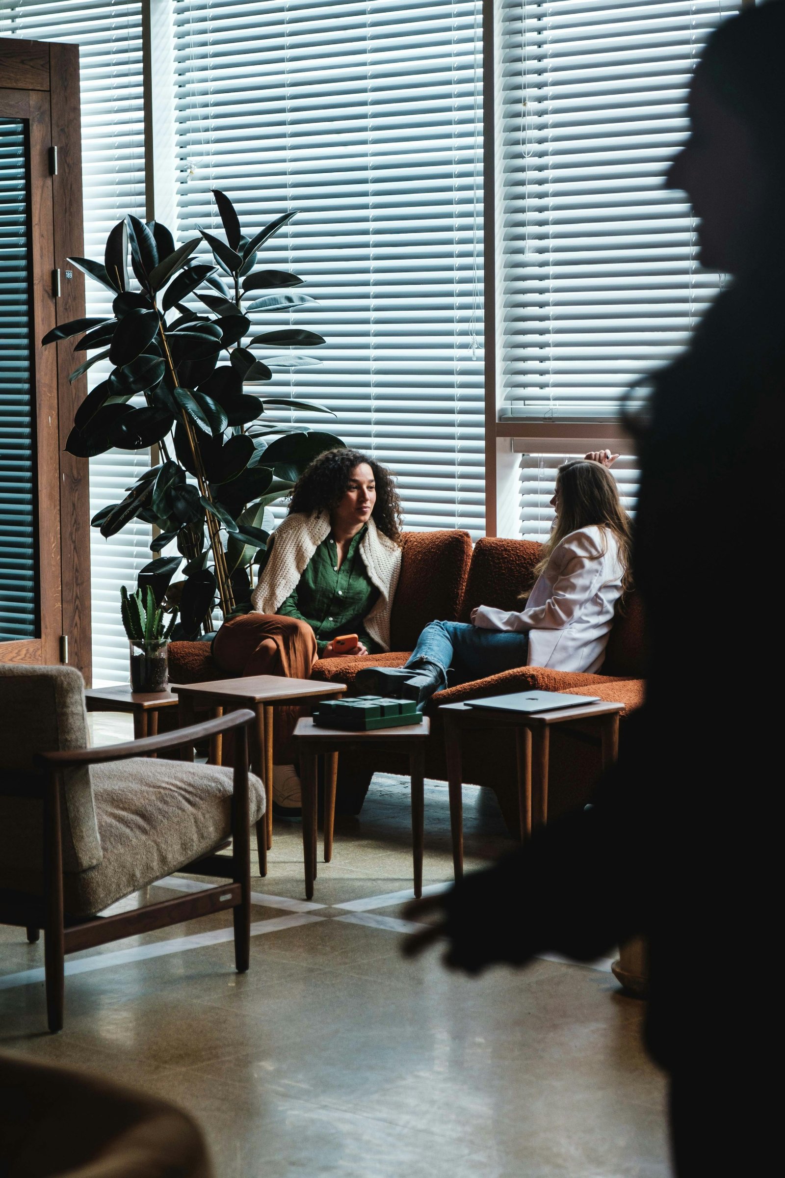 Two women sitting on a couch having a relaxing conversation